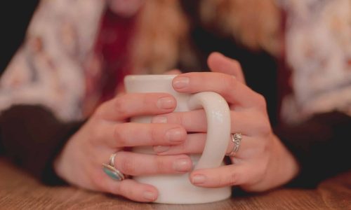person holding white ceramic mug